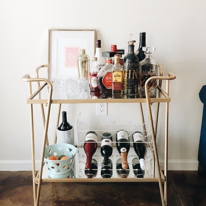 The bar cart adorned with decor and bottles of alcohol