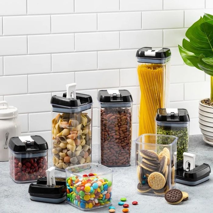 A canister set filled with various foods displayed on a kitchen counter