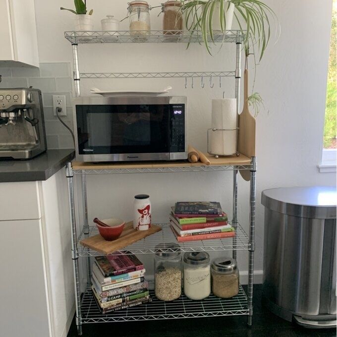 The baker's rack with decor and appliances displayed on it.