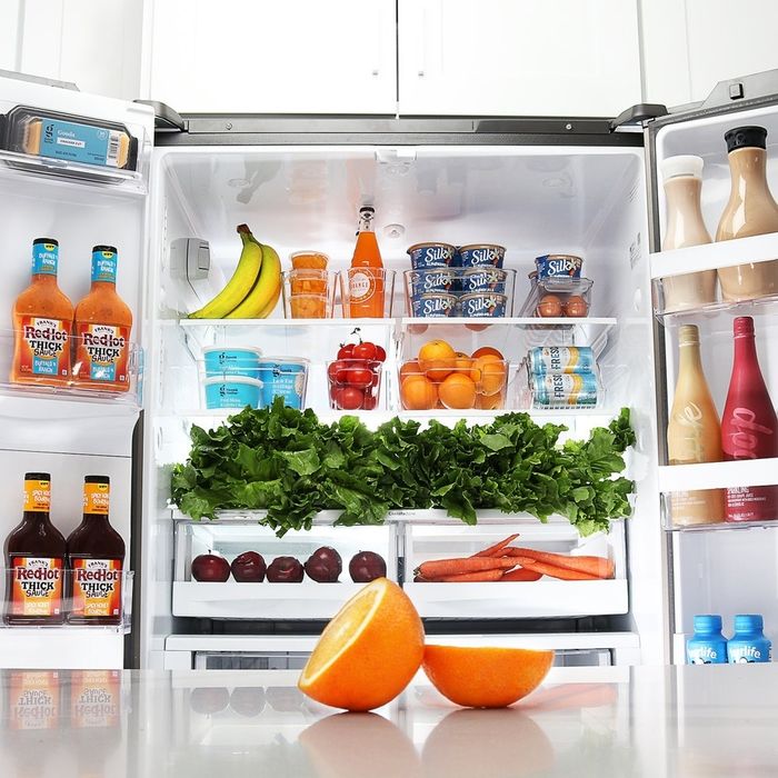 An open fridge, stocked with various foods and neatly organized fridge bins