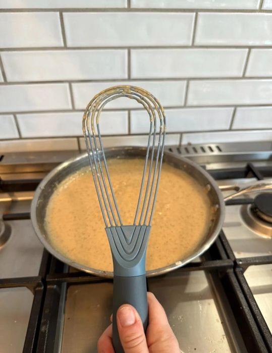 A reviewer demonstrating the whisk in its compact, folded position