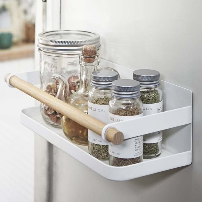 The magnetic rack holding a variety of spice jars on the fridge