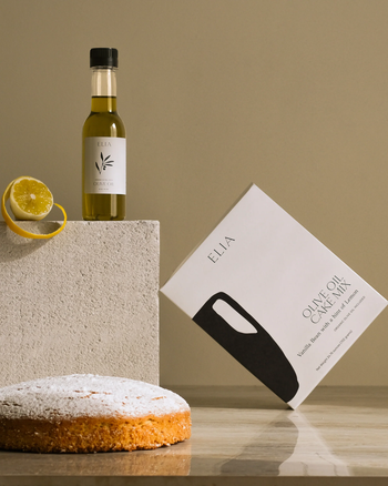 A box of the cake mix next to the olive oil bottle and a freshly baked cake.