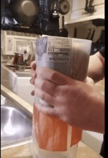 A reviewer using the rectangular bread dispenser to pull out a fresh loaf of bread.