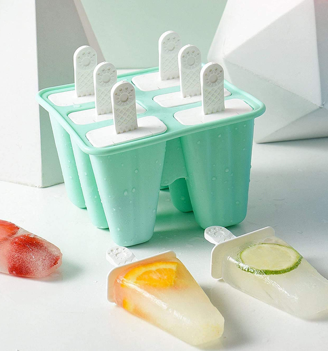 The light green ice pop mold alongside several fruit-flavored popsicles.