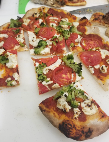 A reviewer shares a photo of a perfectly cooked pizza fresh from the fire oven.