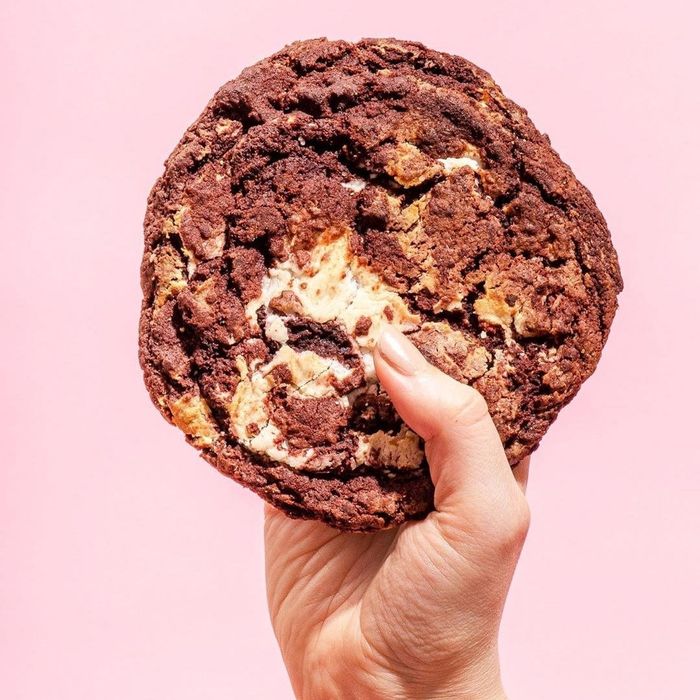 A hand reaching for a freshly baked cookie.