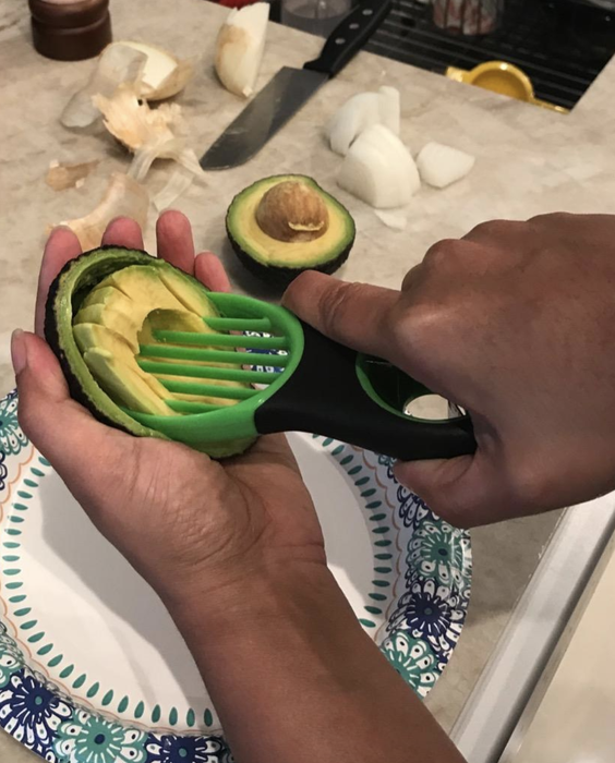 The reviewer slices an avocado with precision using the tool after pitting it.