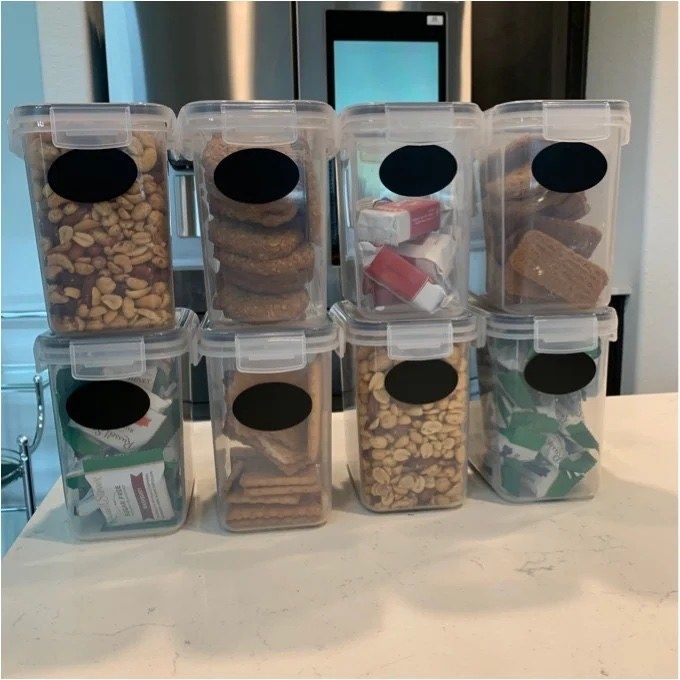 A collection of airtight containers filled with various snacks and nuts resting on the kitchen counter
