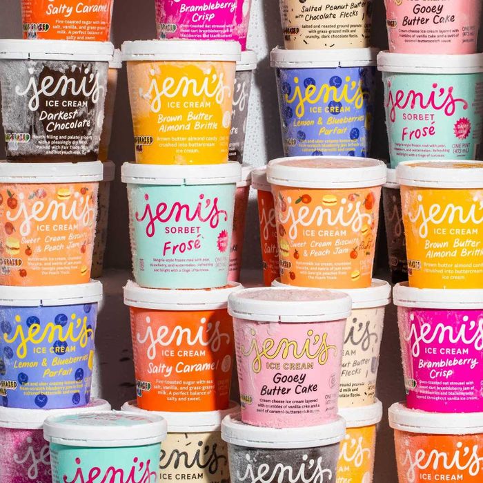 A stack of Jeni's Ice Cream pints in a variety of flavors like Salty Caramel, Brown Butter Almond Brittle, Gooey Butter Cake, and Frosé among others