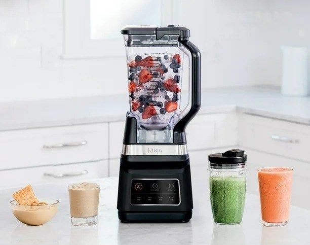 A blender preparing a smoothie in a kitchen setting