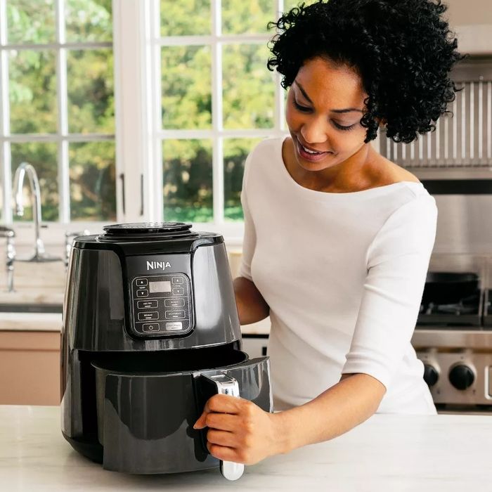 A woman preparing food using the air fryer
