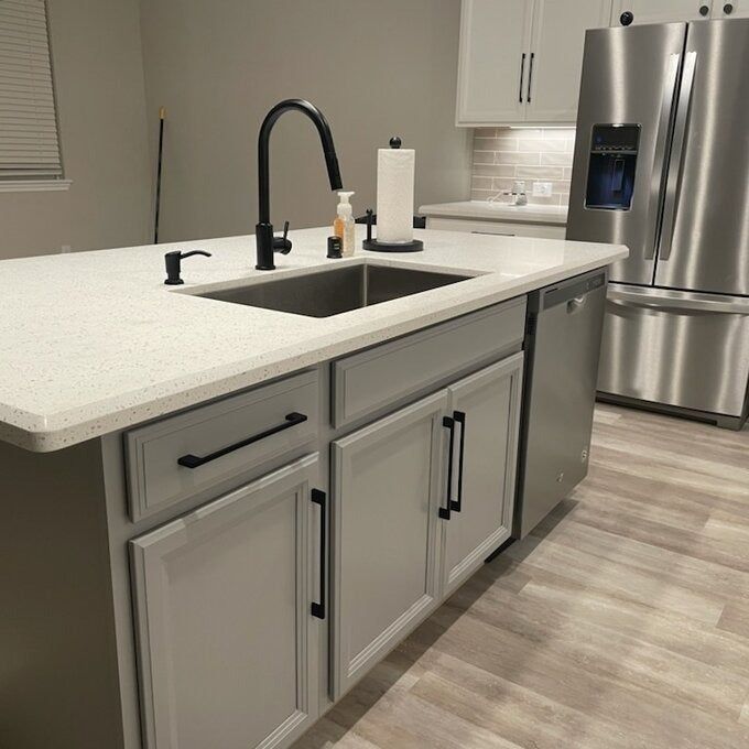 A user photo showing a black kitchen faucet on a white countertop.