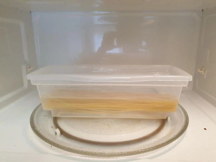 The microwave pasta cooker inside a microwave with pasta inside.