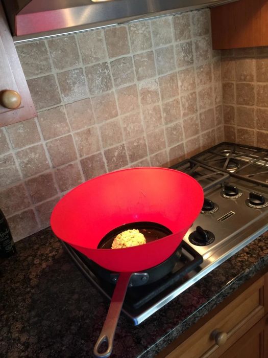 A red skillet cooking food on a stove in the kitchen—perfect for home chefs looking to elevate their cookware collection.