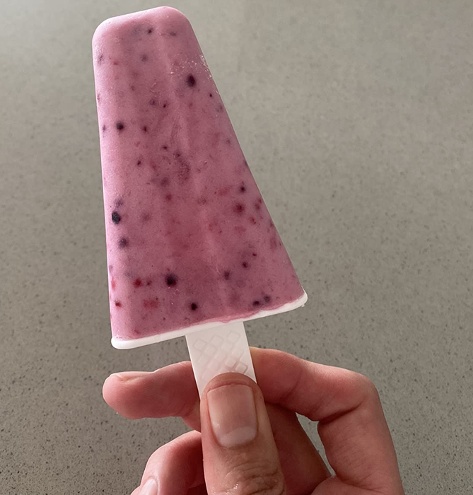 A reviewer proudly displaying a homemade pink popsicle.