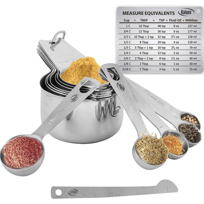 Measuring cups and spoons filled with various spices, with a measurement equivalence chart. Brands visible: Kaluns and Sum.