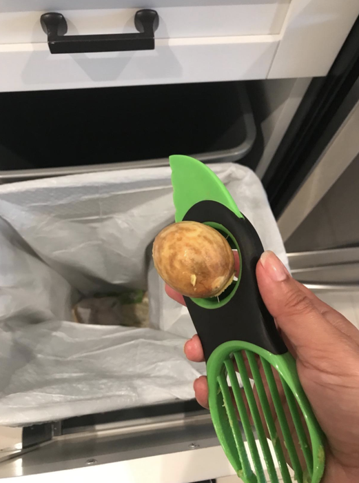A reviewer demonstrates the tool by pitting an avocado, with a hole designed for easy removal of the pit.