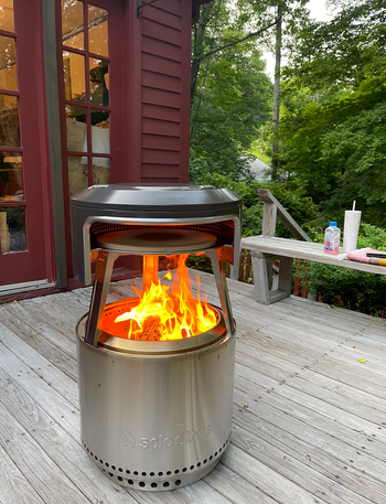 A Solo Stove set up on a backyard porch, ready for cooking.