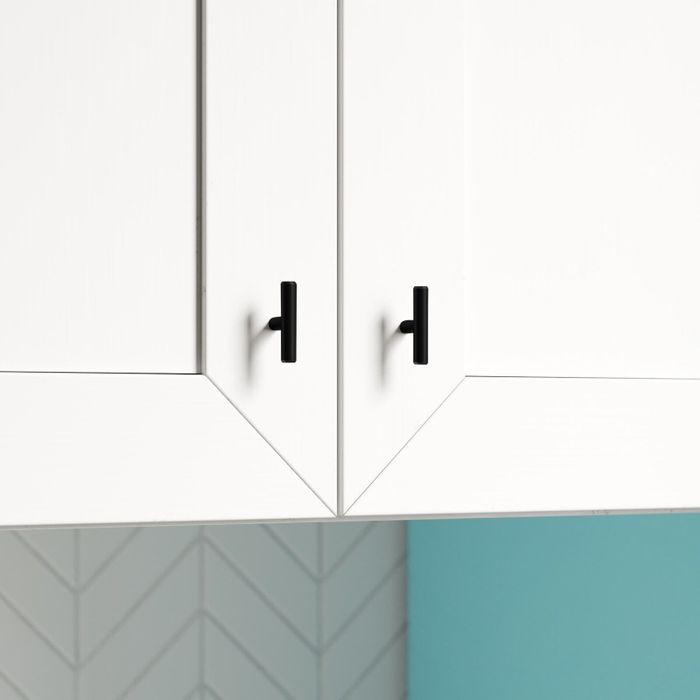 The knobs in black, set against white cabinets.