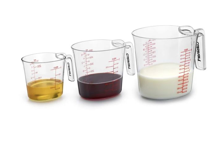 Three measuring cups filled with varying liquid levels, perfect for shopping