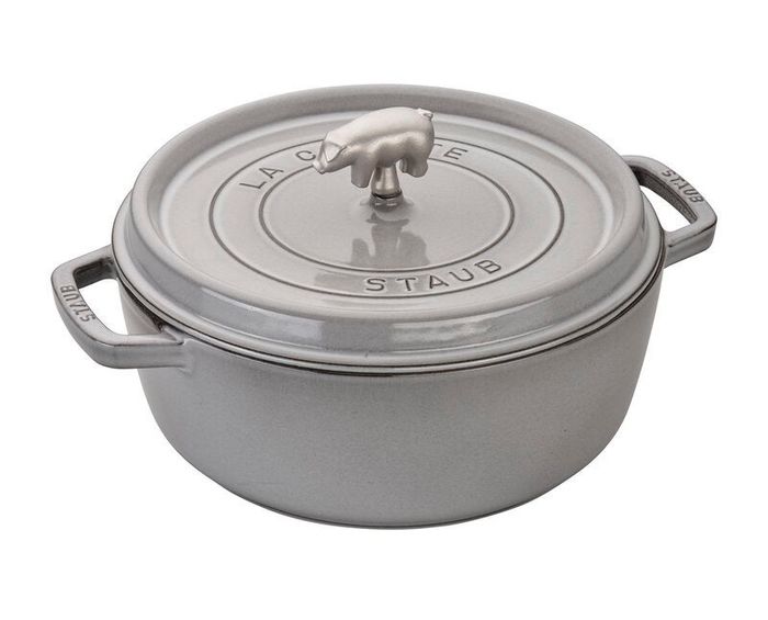 A Staub cast iron cocotte with a lid, featuring two handles and a top knob.