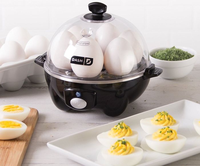 The black egg cooker with six eggs, alongside a tray of deviled eggs.