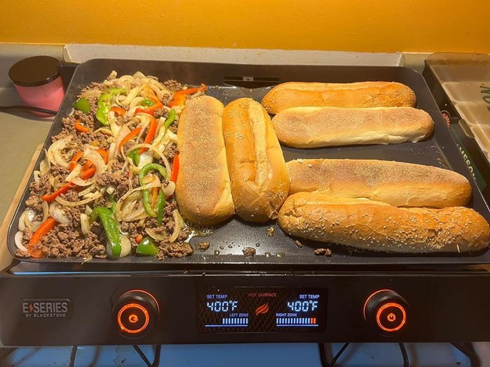 The griddle loaded with sub buns and their fillings