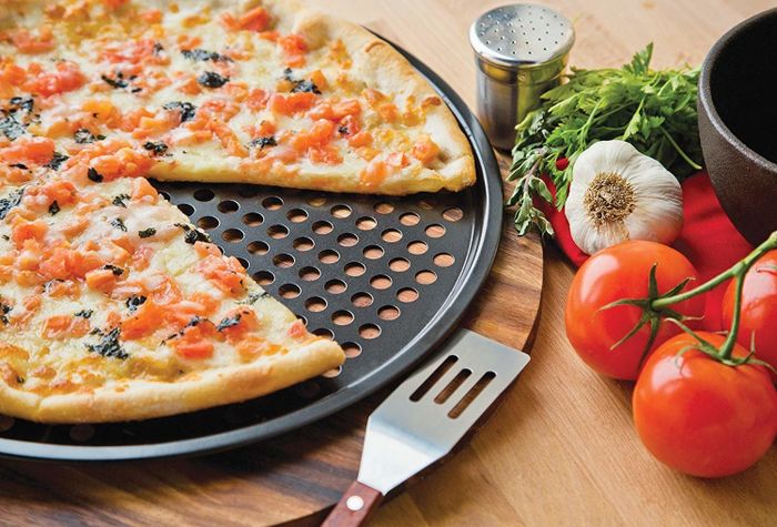 A delicious thin-crust pizza sizzling on the crisping pan.