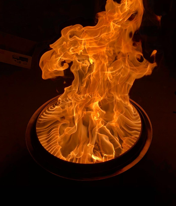 A reviewer sharing a photo of the large, blazing fire coming from their portable fire pit stove.