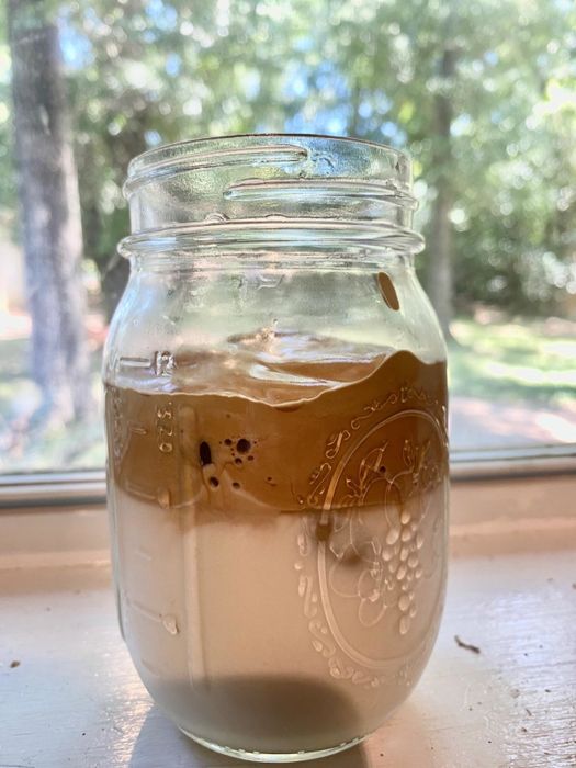 A mason jar filled with milk and topped with whipped coffee.