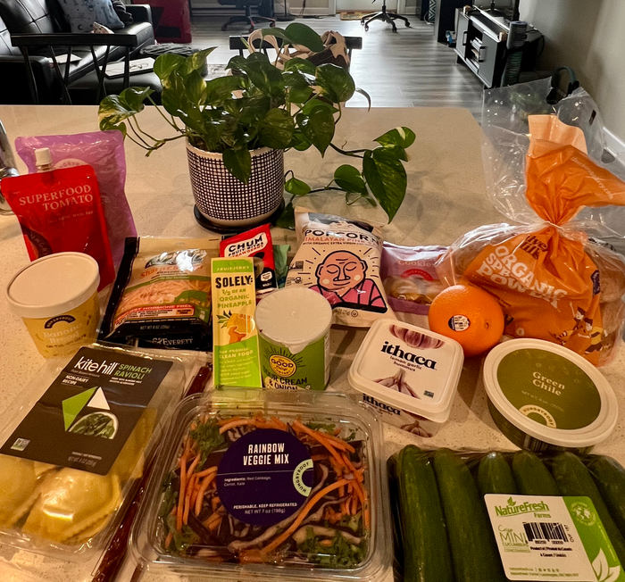 A variety of Hungryroot groceries, including salad mix, dairy-free ravioli, and green chile, displayed on a kitchen countertop