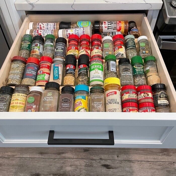 The spice rack neatly placed inside a drawer, holding various spices.