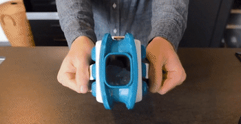 Gif of a person opening the Icebreaker to add ice to a cup of water