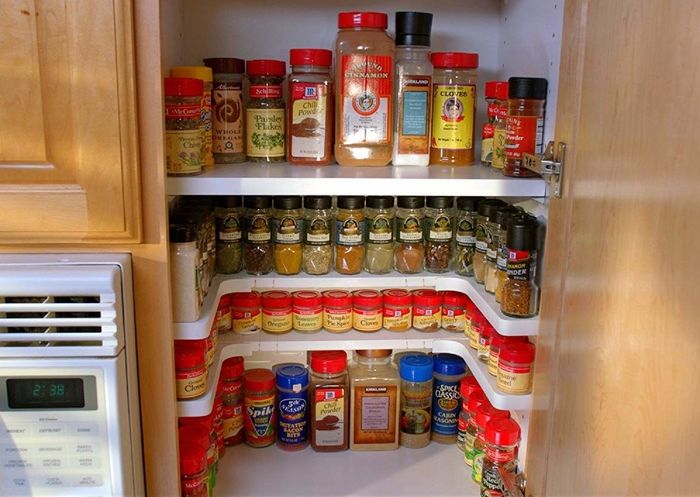 The U-shaped spice rack placed inside a cabinet, neatly organizing spices on top of it for easy access.