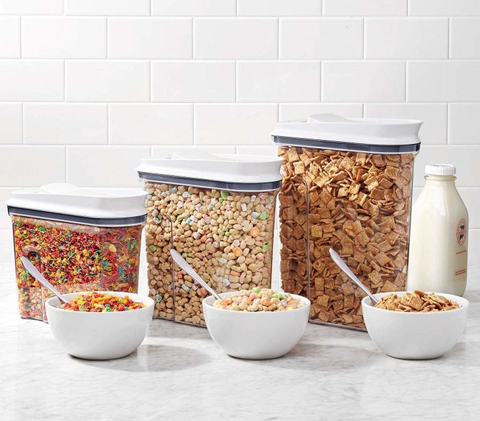 Three containers filled with various types of cereal
