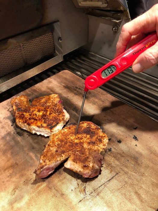 A reviewer checking the temperature of cooked meat.