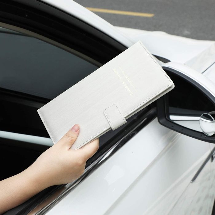 A hand passing the holder through their open car window