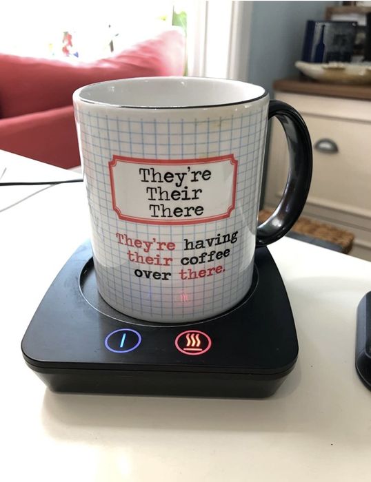 Reviewer's photo of the black warming plate keeping their coffee mug hot