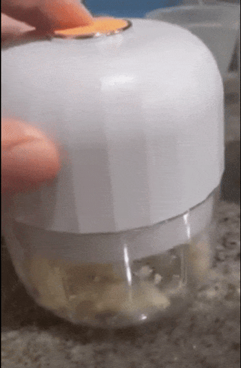 A gif showing a reviewer using the wireless garlic chopper.