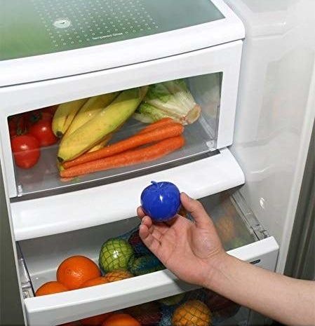 A model placing the small blue apple-shaped product inside a refrigerator drawer