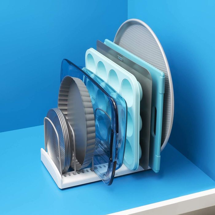 Pie dishes, plates, casserole dishes, cupcake holders, cutting boards, and a pizza tray stacked neatly in an organized holder