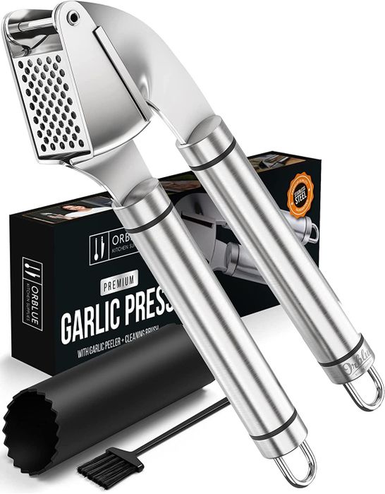 A stainless steel garlic press, displayed alongside its packaging.