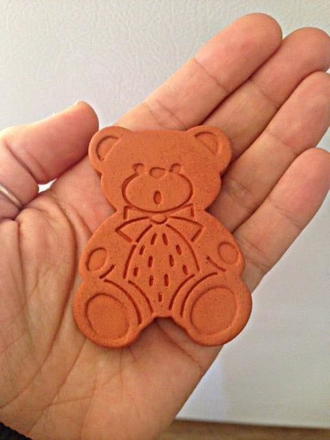 A reviewer holding the bear designed to keep your brown sugar soft and clump-free.