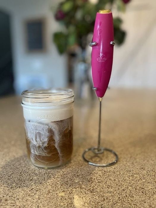 Reviewer's photo of the frother alongside a homemade frothed latte