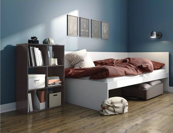 The six-cube organizer filled with a variety of items placed next to the bed