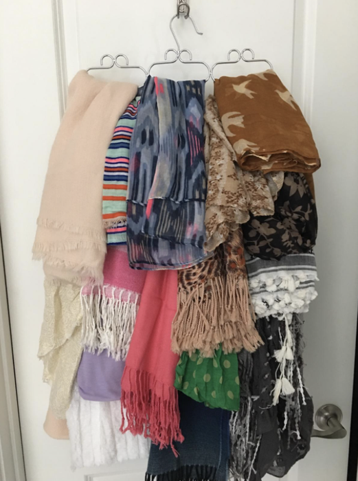 Several scarves neatly hung on the same organized hanger