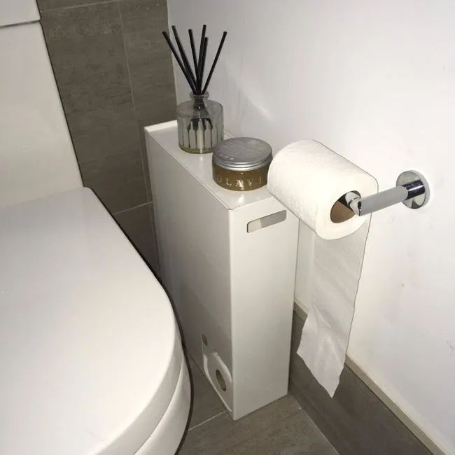 Reviewer photo of the white rectangular holder with a small cutout in the bottom left, showcasing rolls of toilet paper inside.