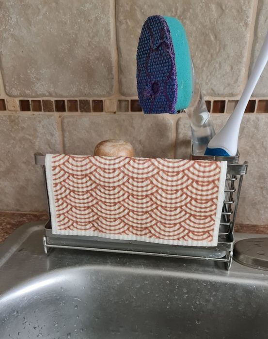 A sponge placed on a soap dish, designed for quick drying and keeping your kitchen tidy