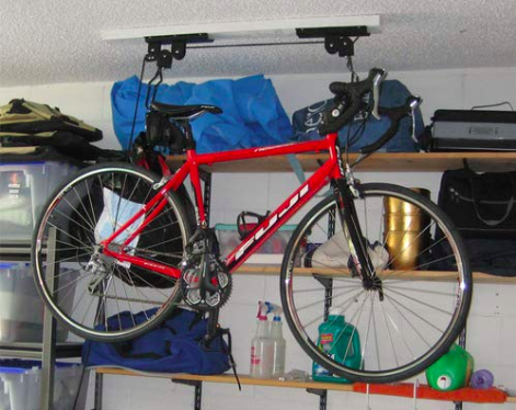 A reviewer's photo of a bike hoisted near the garage ceiling, keeping it out of the way